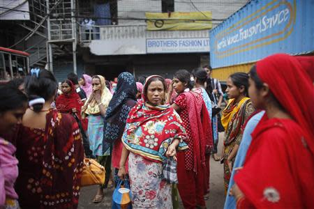 Garment workers exit a Brothers Fashion Limited factory after it closed following a protest in Dhaka September 23, 2013. REUTERS/Andrew Biraj