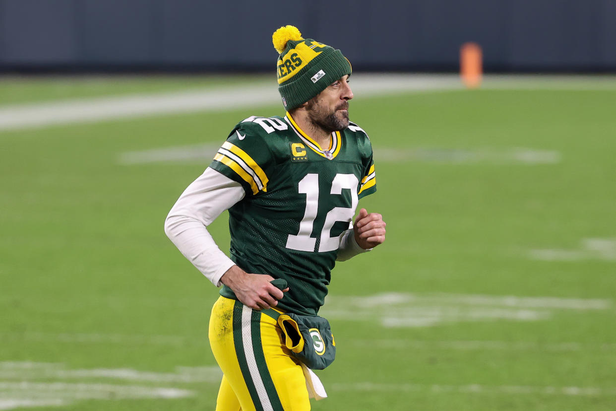 GREEN BAY, WISCONSIN - JANUARY 16: Aaron Rodgers #12 of the Green Bay Packers jogs across the field after beating the Los Angeles Rams 32-18 during the NFC Divisional Playoff game at Lambeau Field on January 16, 2021 in Green Bay, Wisconsin. (Photo by Dylan Buell/Getty Images)