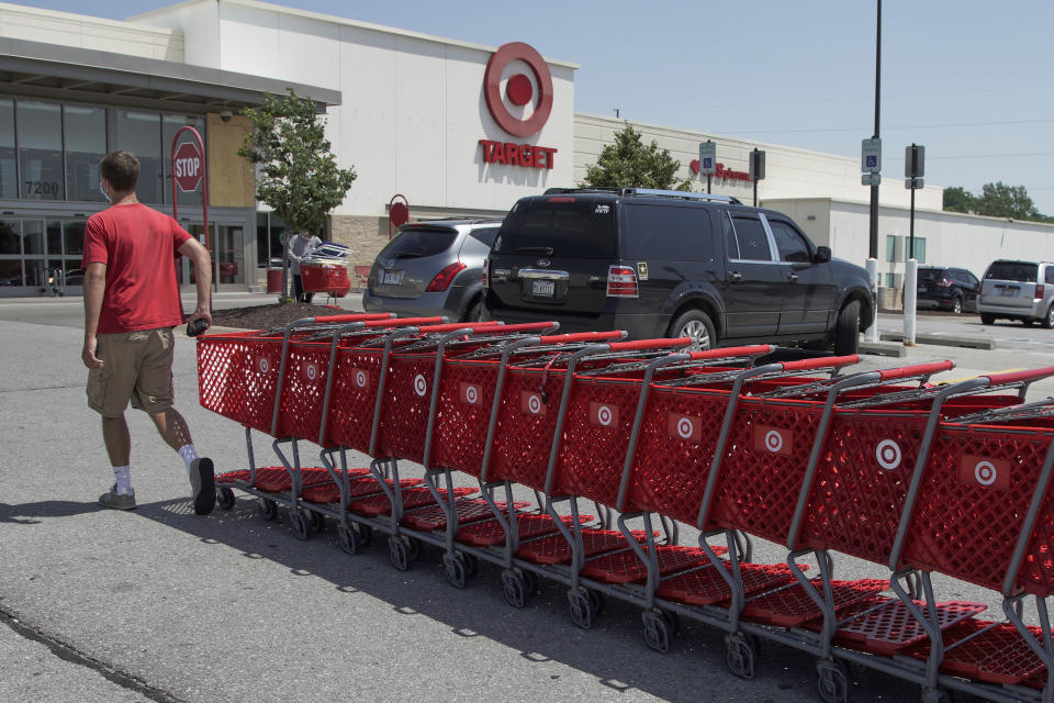 A Target employee returns shopping carts from the parking lot, in Omaha, Neb., Tuesday, June 16, 2020. American shoppers ramped up their spending on store purchases by a record 17.7% from April to May, delivering a dose of energy for retailers that have been reeling since the coronavirus shut down businesses, flattened the economy and paralyzed consumers during the previous two months. (AP Photo/Nati Harnik)