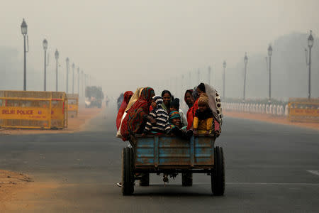 People commute on a motor-cart on a smoggy morning in New Delhi, India, November 5, 2018. REUTERS/Anushree Fadnavis