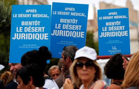 Notaries and bailiffs hold placards as they demonstrate during their first-ever public protest against a plan to chip away at rules shielding them from competition in Marseille September 17, 2014. REUTERS/Jean-Paul Pelissier