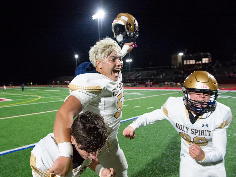 Holy Spirit's Robert McDevitt, center, celebrates with teammates Gavin Cohen, left, and Mason Forte, right, after Holy Spirit defeated Kingsway, 31-27, in the football game played at Kingsway Regional High School in Woolwich Township on Friday, October 21, 2022.  