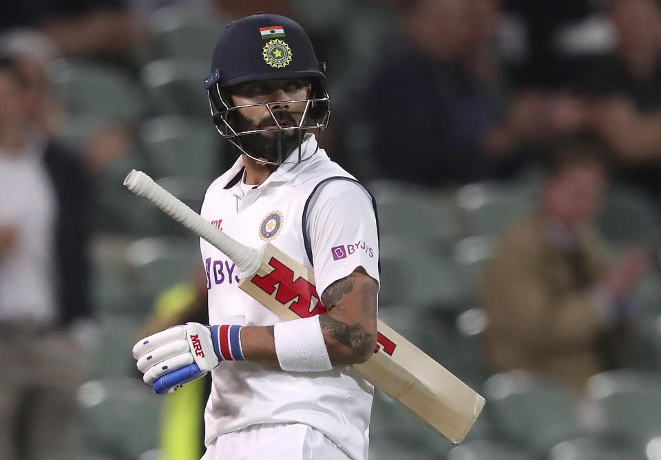 FILE - In this file photo dated Thursday, Dec. 17, 2020, India's Virat Kohli walks off after he was run-out by Australia for 74 runs during their cricket test match at the Adelaide Oval in Adelaide, Australia. A four-match test series between England and India begins Friday Feb. 5, 2021, with England’s spin bowlers facing off against an intimidating Indian batting lineup featuring Virat Kohli, who is available again. (AP Photo/James Elsby, FILE)