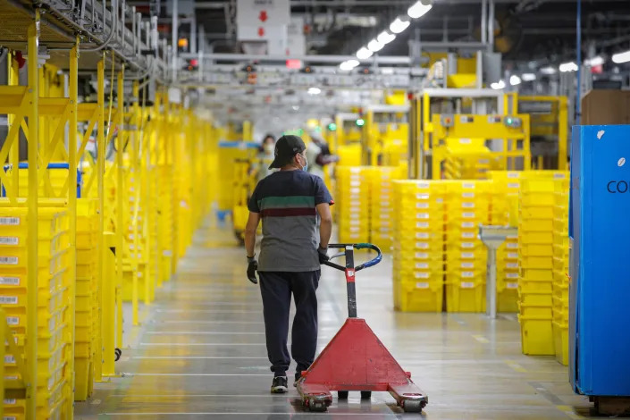 An employee pulls a cart at Amazon&#39;s JFK8 distribution center in Staten Island, New York, U.S. November 25, 2020.  REUTERS/Brendan McDermid.