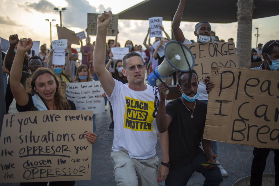 Protesters hold signs and shout slogans during a protest to decry the killing of George Floyd in front of the American embassy in Tel Aviv, Israel, Tuesday, June 2, 2020.(AP Photo/Ariel Schalit)