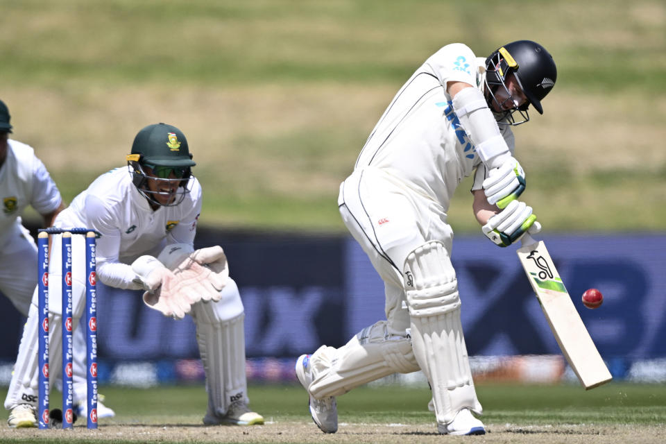 New Zealand's Tom Latham, right, hits a 6 in front of South Africa's Clyde Fortuin on the second day of their cricket test in Hamilton, New Zealand. Wednesday, Feb. 14, 2024. (Andrew Cornaga/Photosport via AP)