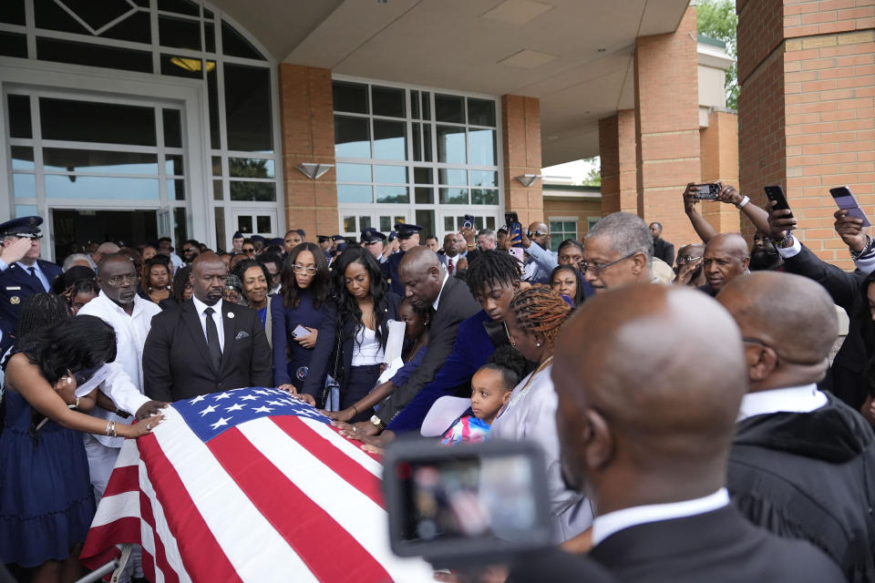 Chantemekki Fortson, right, the mother of slain airman Roger Fortson, along with friends and family touch Fortson's casket as they leave for a cemetery during the funeral for Fortson at New Birth Missionary Baptist Church, Friday, May 17, 2024, in Stonecrest, Ga. (AP Photo/Brynn Anderson)