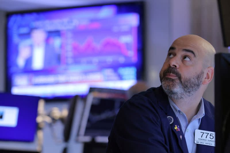 FILE PHOTO: A trader works on the trading floor at the New York Stock Exchange (NYSE) in Manhattan, New York City