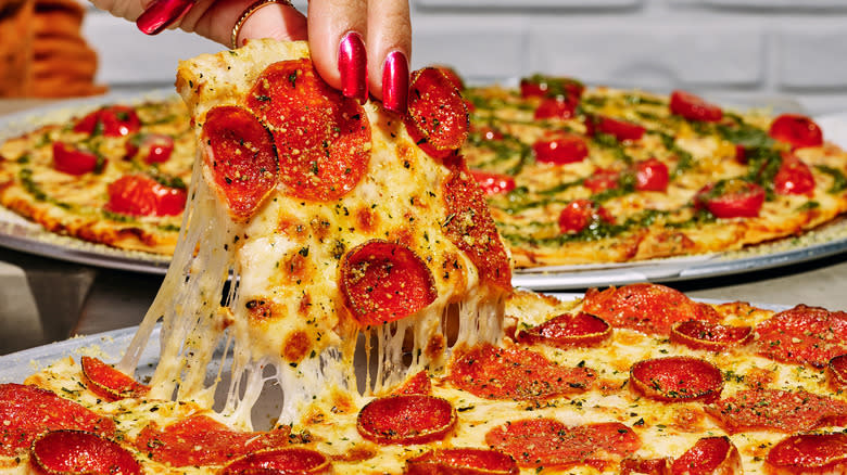 Hand grabbing square pizza slice