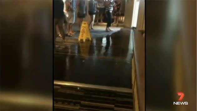 Passengers are standing around unsure of where to stand so their feet don't become drenched in storm water. Photo: 7 News