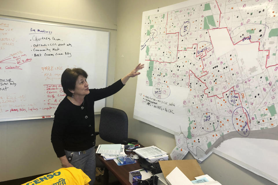 In this Nov. 22, 2019 file photo, Detroit 2020 Census Campaign executive director Victoria Kovari looks over a Detroit map showing city neighborhoods that were under-counted in the 2010 census. Michigan's slow population growth over the past decade will cost the state a U.S. House seat, continuing a decades-long trend as job-seekers and retirees have fled to other states. (AP Photo/Corey Williams)
