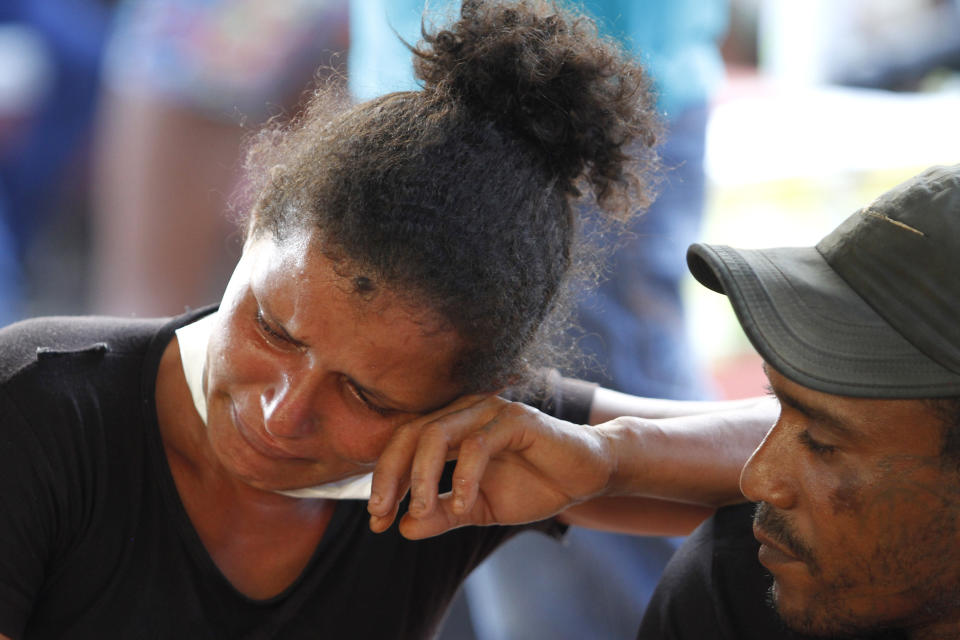 A woman cries as she waits outside the coroner's office in Altamira, Brazil, Tuesday, July 30, 2019. Relatives of inmates killed during a prison riot in northern Brazil gathered at the coroner's office Tuesday to identify the 57 victims, with some passing out at seeing the beheaded corpse of a loved one. (AP Photo/Raimundo Pacco)