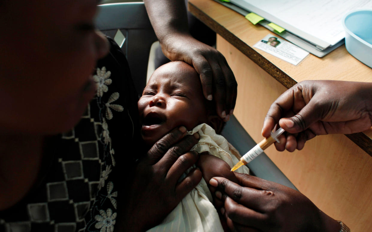 A mother holds her baby receiving a new malaria vaccine as part of a trial at the Walter Reed Project Research Center in Kombewa in Western Kenya - Copyright 2017 The Associated Press. All rights reserved.