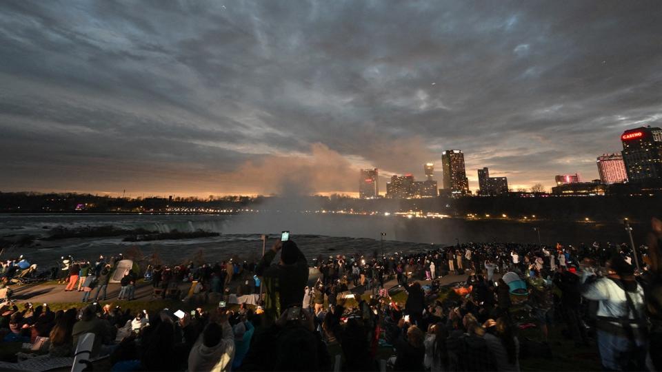 <div>The sky darkens as people watch during totality of the total solar eclipse across North America, at Niagara Falls State Park in Niagara Falls, New York, on April 8, 2024. This year's path of totality is 115 miles (185 kilometers) wide and home to nearly 32 million Americans, with an additional 150 million living less than 200 miles from the strip. The next total solar eclipse that can be seen from a large part of North America won't come around until 2044. (Photo by ANGELA WEISS / AFP) (Photo by ANGELA WEISS/AFP via Getty Images)</div> <strong>(Getty Images)</strong>