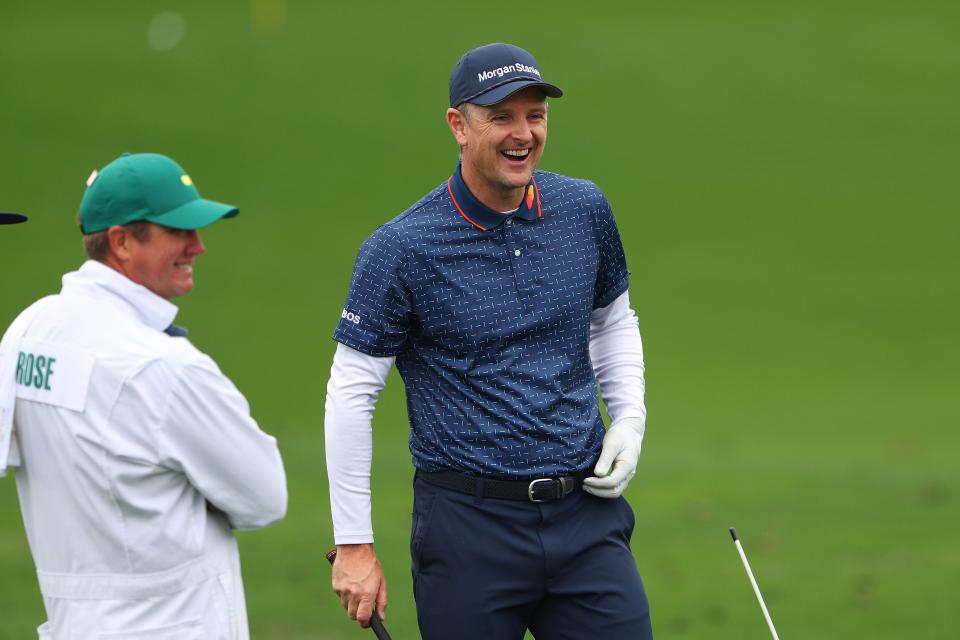 Justin Rose laughs with his caddie during the Monday practice round at the 2023 Masters