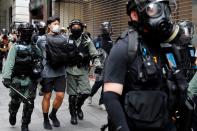 Riot police officers detain an anti-government demonstrator during a protest at Central District against the second reading of a controversial national anthem law in Hong Kong