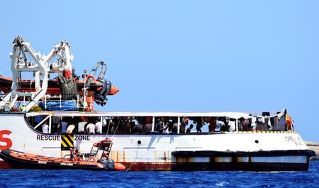 Migrants are seen aboard Spanish migrant rescue ship Open Arms, close to the Italian shore in Lampedusa