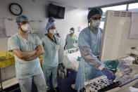 Medical staff members care for a COVID-19 patient in the intensive care unit at the Strasbourg University Hospital, eastern France, Thursday Jan. 13, 2022. The omicron variant is exposing weaknesses at the heart of Europe's public health system. In France and Britain, a sharp rise in coronavirus hospitalizations coupled with staff falling sick has led to a shortage of beds. (AP Photo/Jean-Francois Badias)