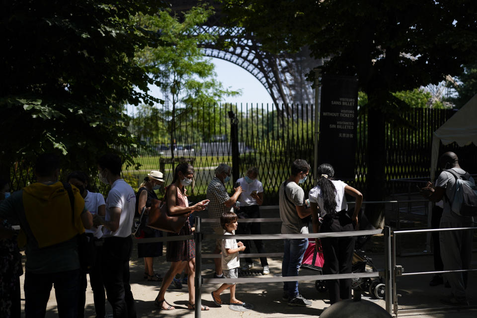 Visitors present covid-19 tests at the entrance of the Eiffel Tower in Paris, Wednesday, July 21, 2021. Visitors now need a special COVID pass to ride up the Eiffel Tower or visit French museums or movie theaters, the first step in a new campaign against what the government calls a "stratospheric" rise in delta variant infections. (AP Photo/Daniel Cole)