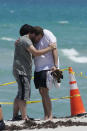 Two men console each other on the beach near the site of the Champlain Towers South condo tower, Sunday, June 27, 2021. One hundred fifty-nine people were still unaccounted for two days after the building partially collapsed on Thursday. (AP Photo/Marta Lavandier)