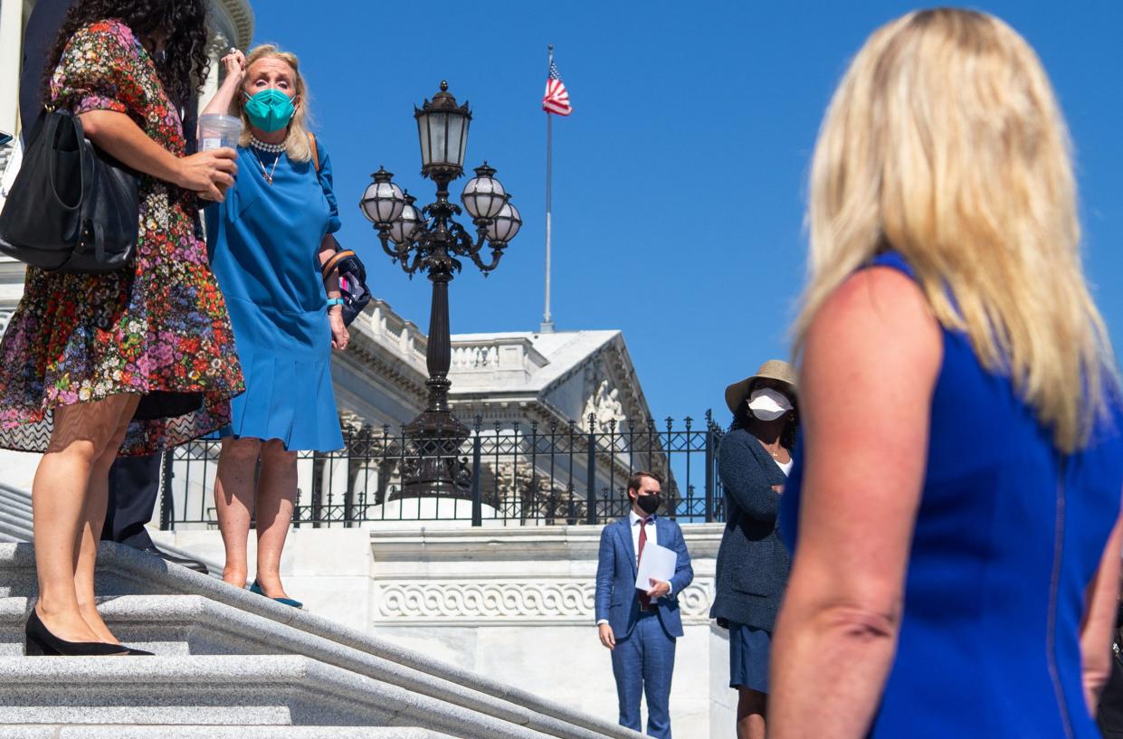 Representative Debbie Dingell (2nd L), Democrat of Michigan, shouts at Representative Marjorie Taylor Greene (R), Republican of Georgia, after Greene started yelling at House Democratic members of Congress as the House Democratic Women's Caucus prepares to hold a press conference promoting the Build Back Better agenda on the steps of the US Capitol in Washington, D.C. on Friday, September 24, 2021.