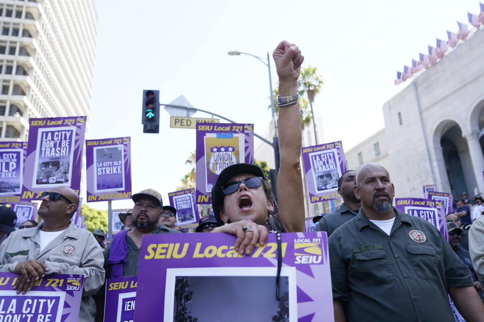 Workers shout slogans outside of City Hall Tuesday, Aug. 8, 2023, in Los Angeles. Thousands of Los Angeles city employees, including sanitation workers, engineers and traffic officers, walked off the job for a 24-hour strike alleging unfair labor practices. The union said its members voted to authorize the walkout because the city has failed to bargain in good faith and also engaged in labor practices that restricted employee and union rights. (AP Photo/Ryan Sun)