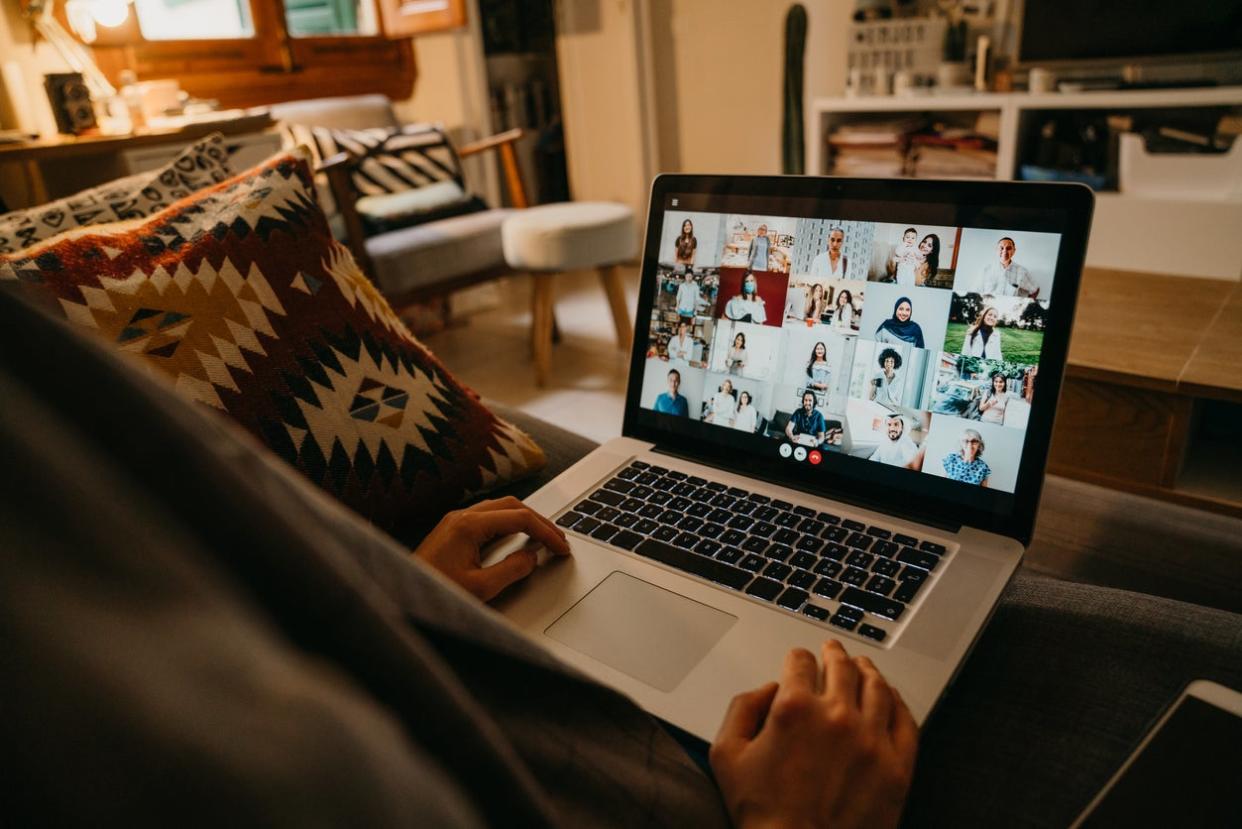 <p>A young woman uses a laptop on the sofa at home to have a work conference call.</p> (Getty Images/iStockphoto)