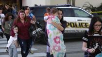 San Antonio police help shoppers exit the Rolling Oaks Mall, Sunday, Jan. 22, 2017, in San Antonio, after a deadly shooting. Authorities say several were injured after a robbery at the shopping mall. (AP Photo/Eric Gay)