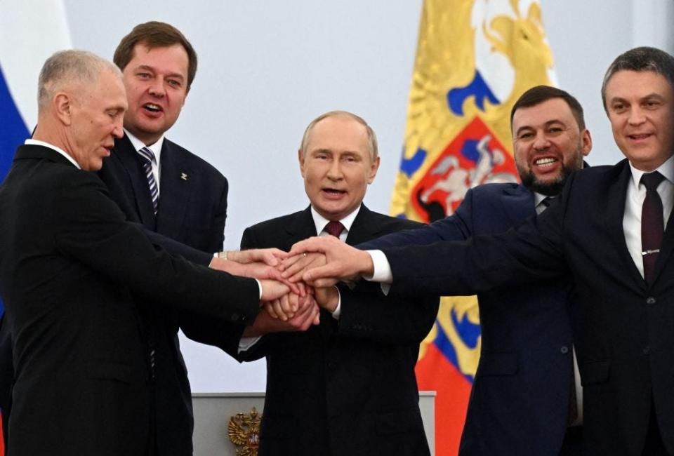 The Moscow-appointed heads of Kherson region Vladimir Saldo and Zaporizhzhia region Yevgeny Balitsky, Russian President Vladimir Putin, Donetsk separatist leader Denis Pushilin and Lugansk separatist leader Leonid Pasechnik join hands after signing treaties formally annexing four regions of Ukraine Russian troops occupy, at the Kremlin in Moscow on September 30, 2022.