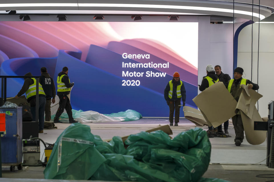 Workers dismantle a booth after that the 90th Geneva International Motor Show (GIMS) is cancelled by Swiss authorities, at the Palexpo in Geneva, Switzerland, Friday, Feb. 28, 2020. The 90th edition of the International Motor Show, scheduled to begin on March 5th, is cancelled due to the advancement of the (Covid-19) coronavirus in Switzerland. The Swiss confederation announced today that all events involving more than 1,000 people would be banned until 15 March. (KEYSTONE/Salvatore di Nolfi)