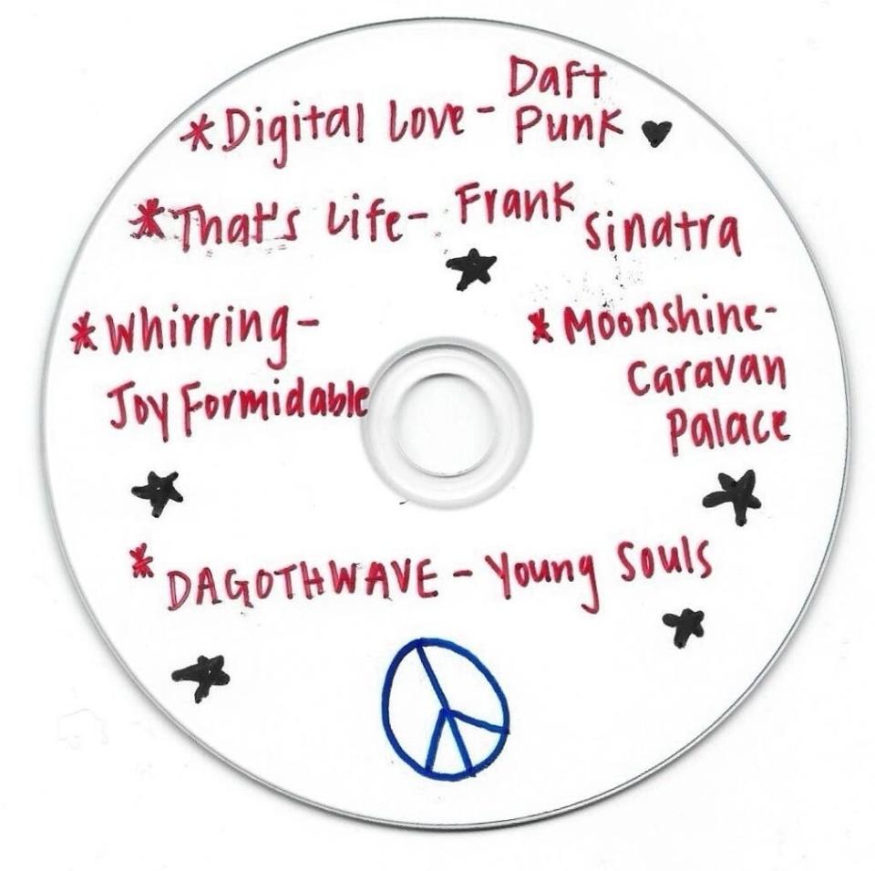 Handwritten list of songs with artists on a CD, including "Digital Love" by Daft Punk, decorated with stars and a peace sign