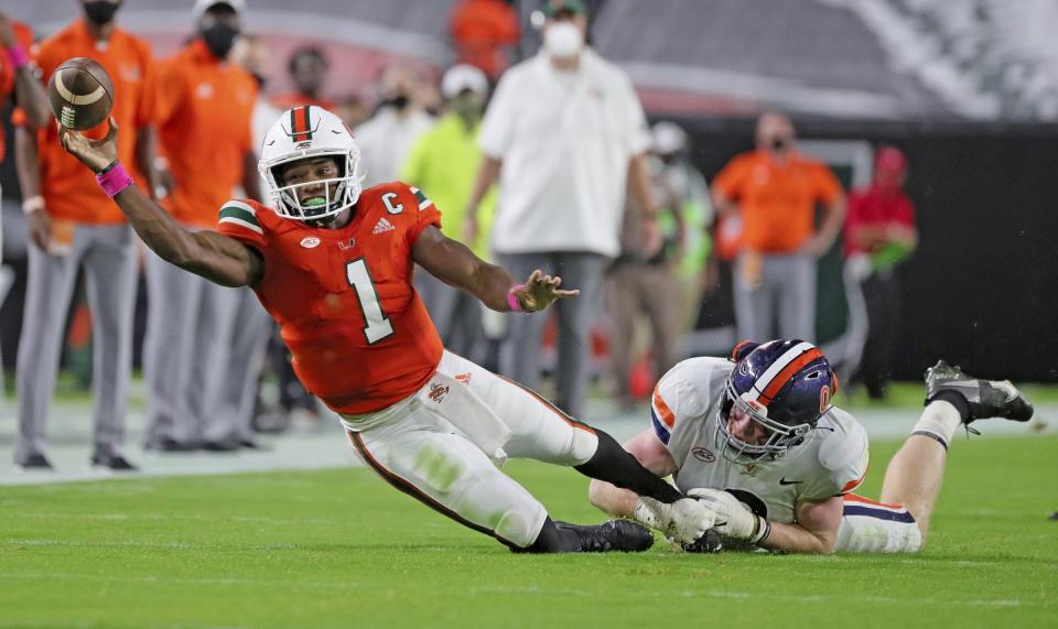 Miami quarterback D'Eriq King (1) is tackled by Virginia's Zane Zandier (1) in the first half of an NCAA college football game in Miami Gardens, Fla., Saturday, Oct. 24, 2020. (Al Diaz/Miami Herald via AP)