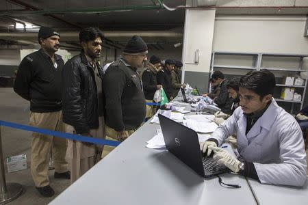 Police officers queue to deliver evidence to be tested at Punjab Forensic Science Agency in Lahore January 13, 2015. REUTERS/Zohra Bensemra