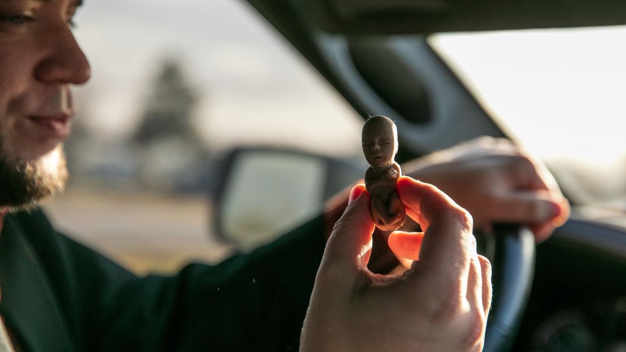 Mark Lee Dickson holds one of the plastic "fetal models" in the cab of his truck. (Photo: Ilana Panich-Linsman for HuffPost)