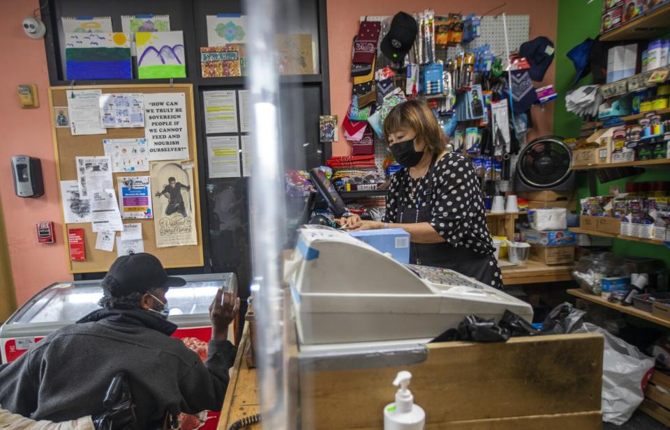 May Park, 67, speaks with a customer in a wheelchair as she works at Skid Row People's Market.