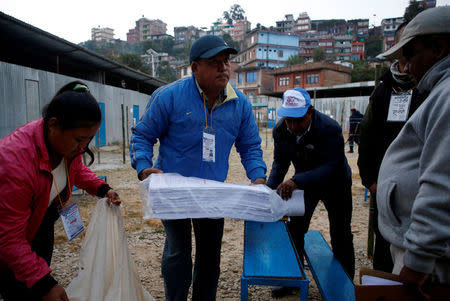 An officer (C) from election commission carries a bunch of ballot papers during the parliamentary and provincial elections at Chautara in Sindhupalchok District November 26, 2017. REUTERS/Navesh Chitrakar