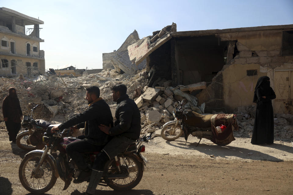 People remove their furniture and household appliances out of a collapsed building following a devastating earthquake in the town of Jinderis, Aleppo province, Syria, Tuesday, Feb. 14, 2023. The death toll from the earthquakes of Feb. 6, that struck Turkey and northern Syria is still climbing. (AP Photo/Ghaith Alsayed)