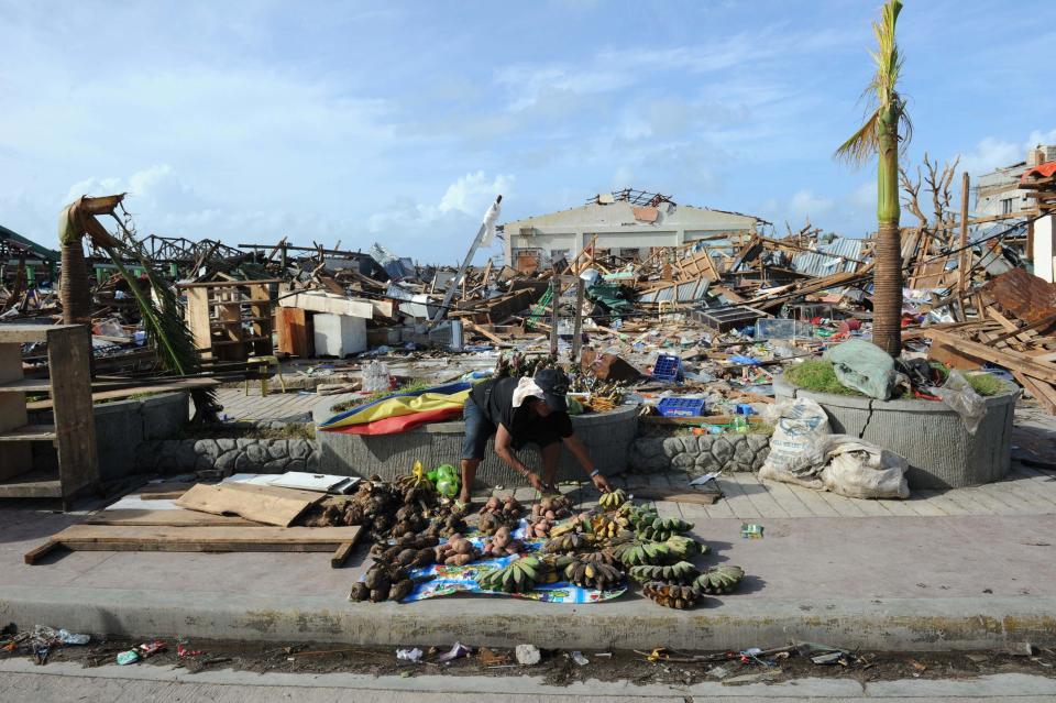 A man sells food next to a destroyed public market after super typhoon Haiyan hit Guiuan