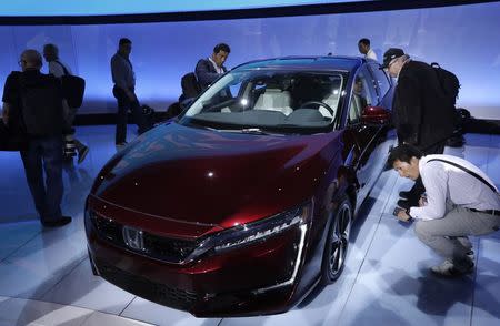 Journalists look over the fuel cell version of the Honda Clarity being displayed at the 2017 New York International Auto Show in New York City, U.S. April 12, 2017. REUTERS/Lucas Jackson