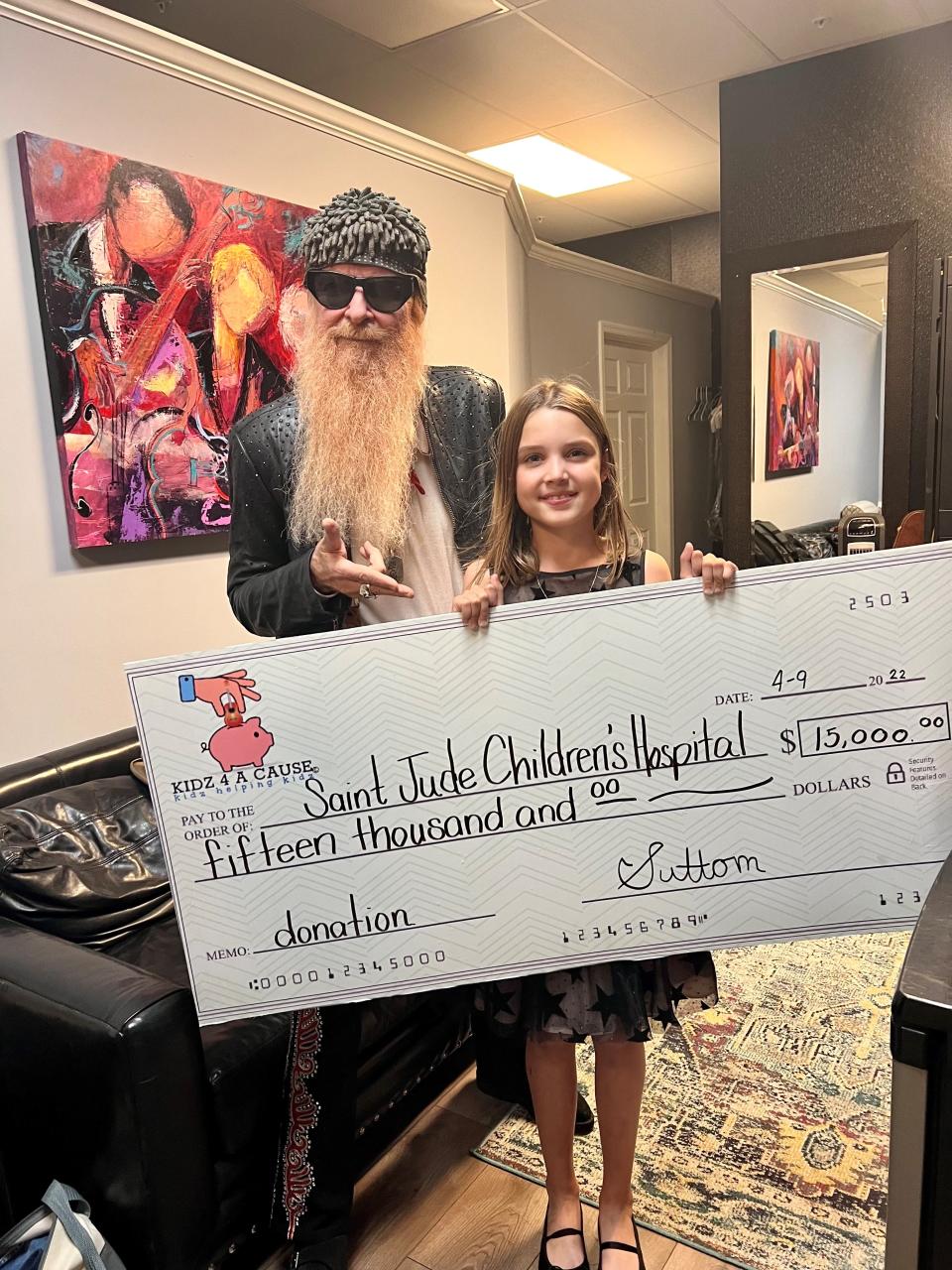 ZZ Top's Billy Gibbons poses with 10-year-old Sutton Shanahan at Saturday's Southwest Florida Event Center concert. Sutton raised more than $15,000 for St. Jude Children's Hospital over the last few months through her charity Kidz 4 a Cause, and she displayed the check onstage at the show.