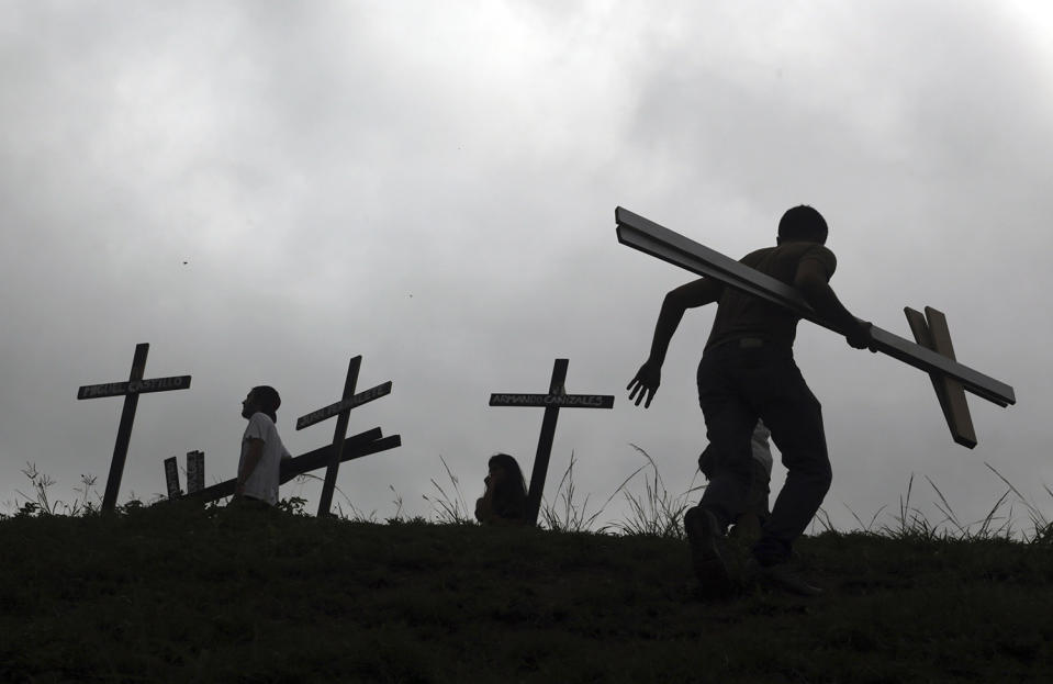 <p>People place crosses, representing people who have died during the most recent opposition protest movement, on the side of the highway during a national sit-in against President Nicolas Maduro, in Caracas, Venezuela, May 15, 2017. Opposition leaders are demanding immediate presidential elections. (Photo: Fernando Llano/AP) </p>