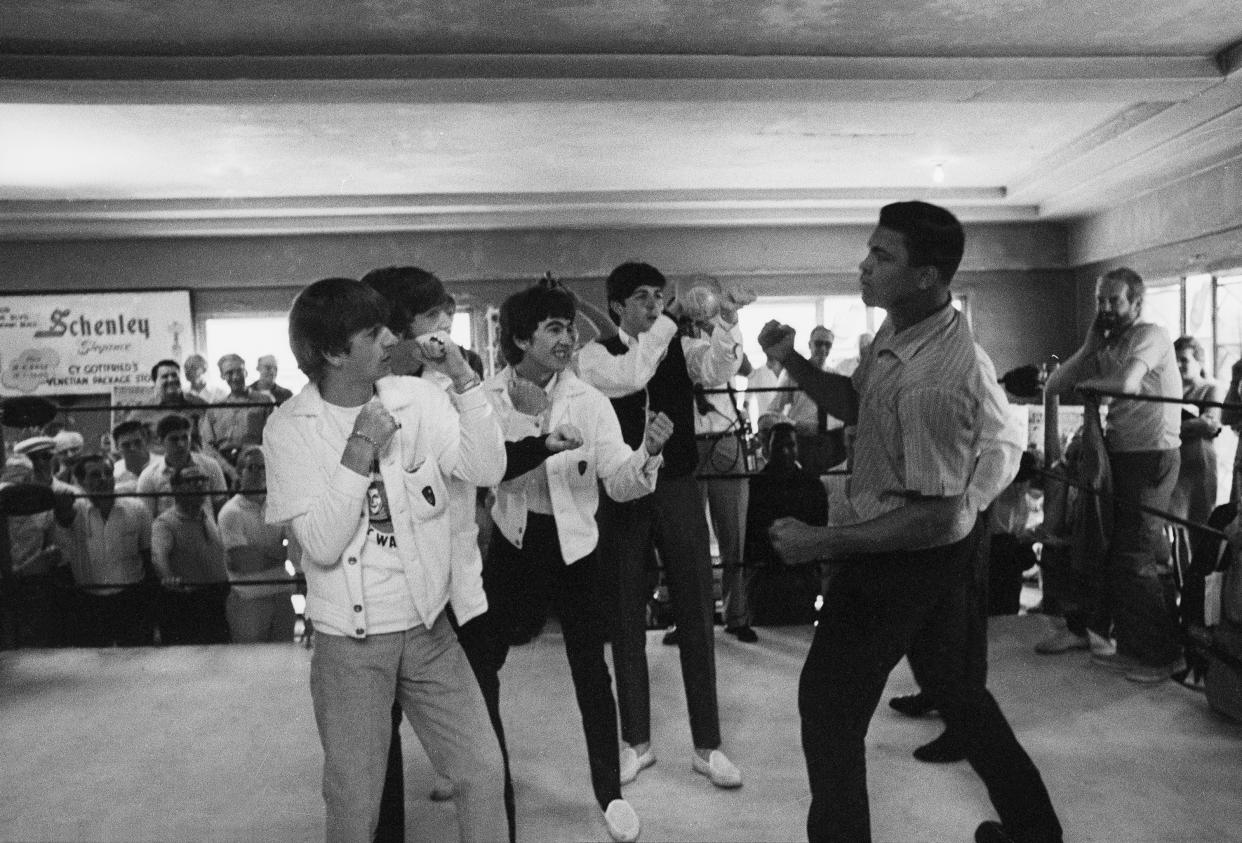 Turning to new fields, Britain's Beatles take on heavyweight challenger Cassius Clay at his training camp in Miami Beach, Florida, Feb. 18, 1964.  From left: Ringo Starr, John Lennon, George Harrison, Paul McCartney and Clay. (AP Photo)