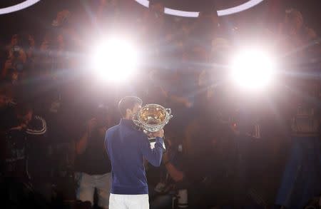 Serbia's Novak Djokovic kisses the men's singles trophy after winning his final match against Britain's Andy Murray at the Australian Open tennis tournament at Melbourne Park, Australia, January 31, 2016. REUTERS/Brandon Malone