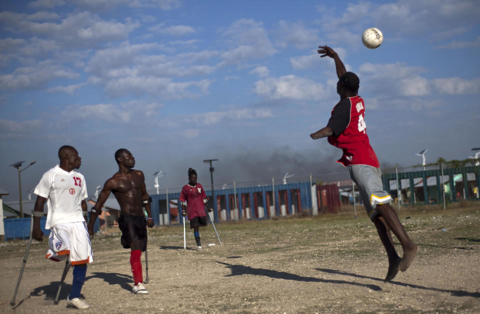 In this picture taken on Feb. 23, 2012, amputees, some whose limbs were amputated due to an injuries suffered in the 2010 earthquake, play soccer at La Piste camp in Port-au-Prince, Haiti. While more than a million people displaced by the 2010 quake ended up in post-apocalyptic-like tent cities, some of the homeless people with disabilities landed in the near-model community of La Piste, a settlement of plywood shelters along tidy gravel lanes. However, the rare respite for the estimated 500-plus people living at the camp is coming to an end as the government moves to reclaim the land. (AP Photo/Ramon Espinosa)