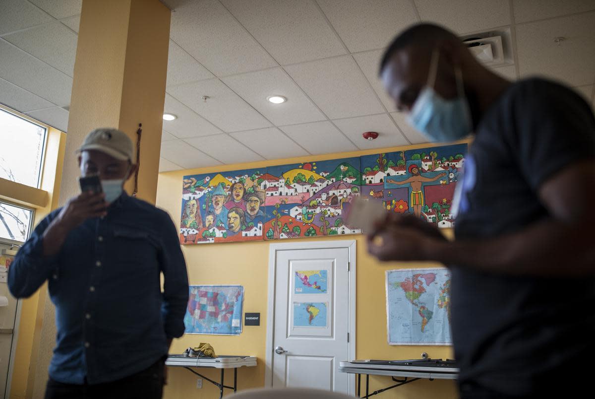 Migrants wait inside a local migrant shelter, Annunciation House, after leaving immigration court, Tuesday, August 23, 2022, in El Paso.