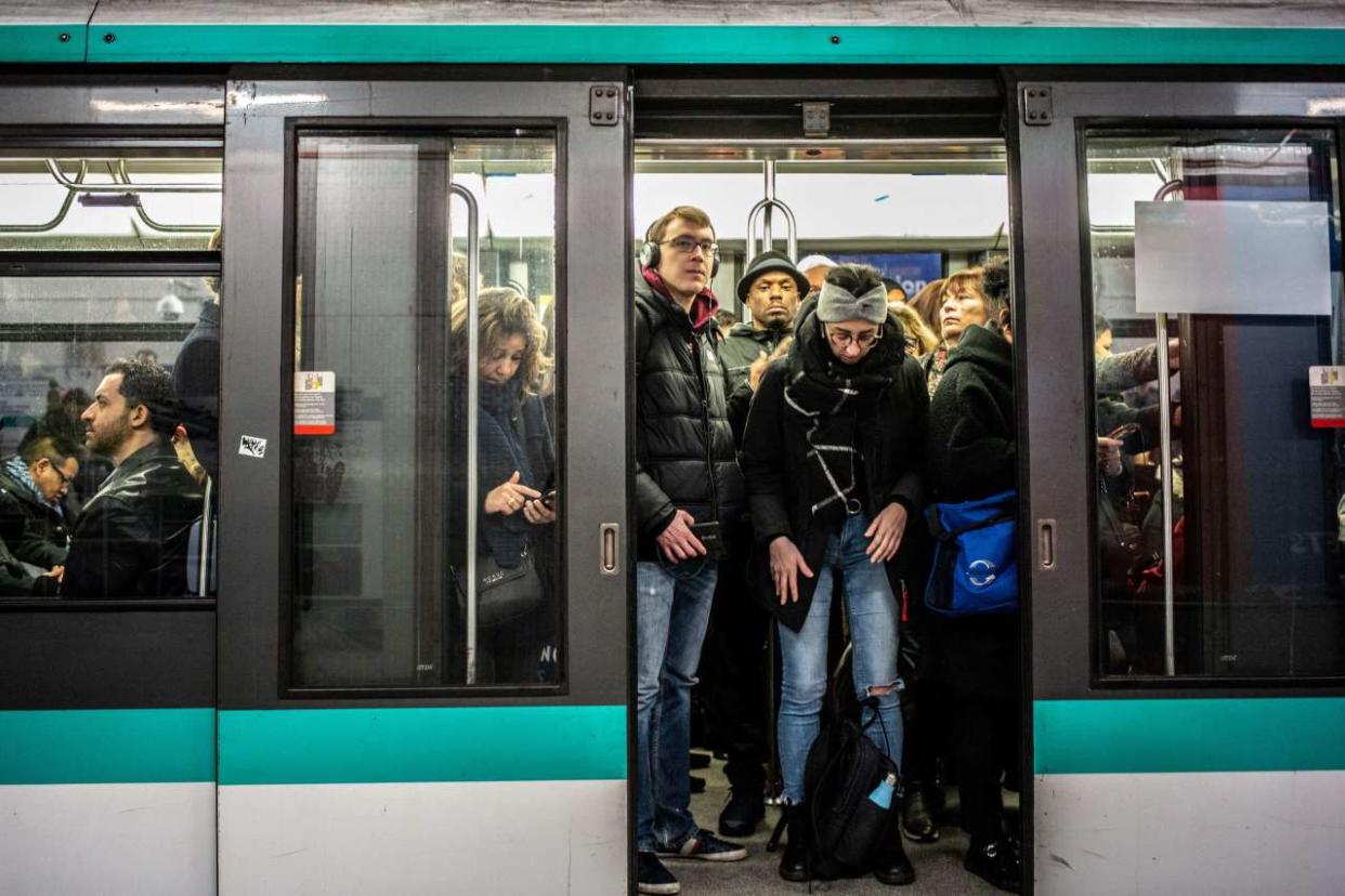 People commute in a metro in Paris,on January 10, 2020, on the 37th day of a strike of French state rail company SNCF and Paris public transports operator RATP employees over the French government's plan to overhaul the country's retirement system. (Photo by Martin BUREAU / AFP)