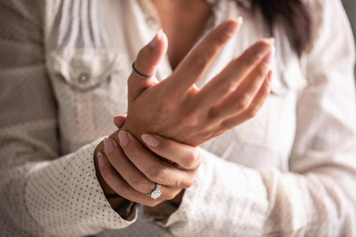 Detail of a woman holding her hand in pain caused by a carpal tunnel. arthritis HRT
