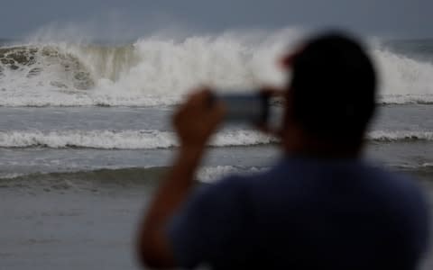 A man photographs the waves before the arrival of the Hurricane Maria in Guayama, Puerto Rico  - Credit: CARLOS GARCIA RAWLINS/Reuters