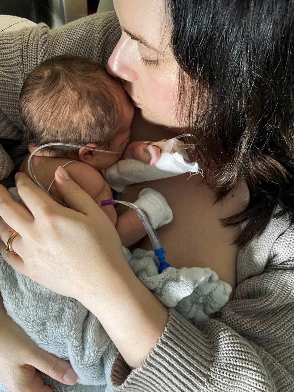 Lauren Sanford kisses the forehead of her son, Oliver, while at Seattle Children’s Hospital.