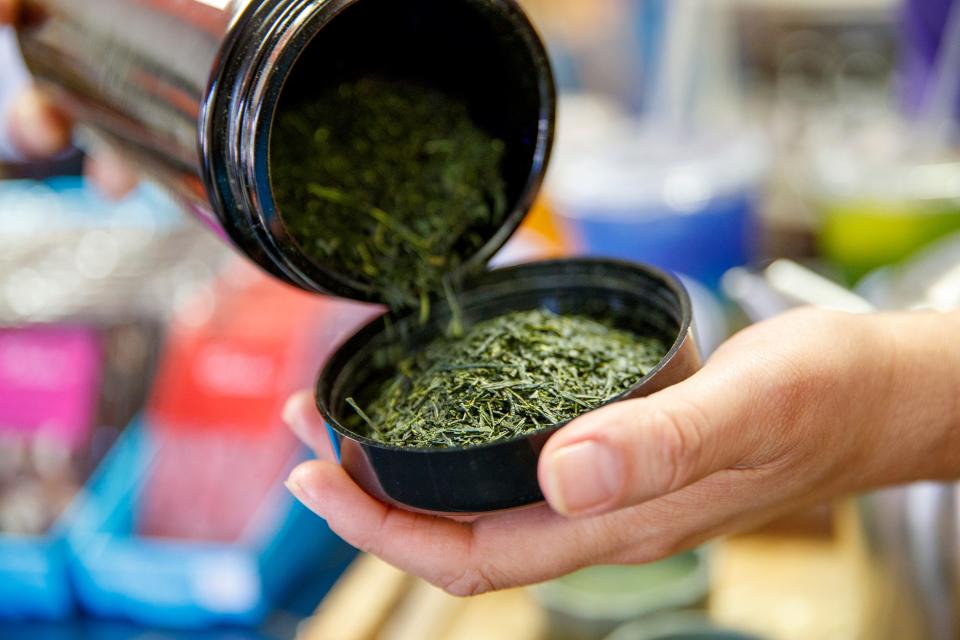 Jodie Smith pours some green leaf tea inside Cali Rosina Tea and Chocolate in La Quinta, Calif., on June 13, 2022. The shop, owned by siblings Josh and Jodie Smith, is expanding to include a tasting room for the extensive selection of teas and chocolates. 